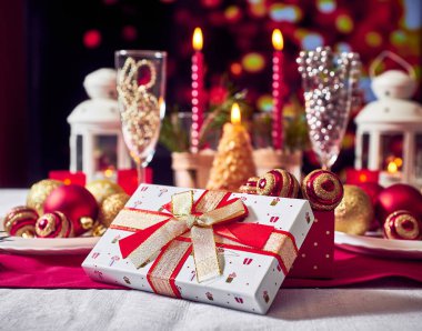 Kırmızı mumlar, ışıklar, altın toplar, masada Noel süsleri. Yakın çekim, seçici odaklanma.