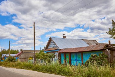 Old traditional wooden houses on the street of the old village. Summer view.