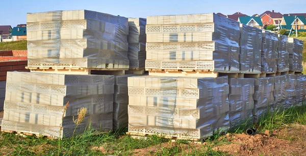 Smooth stacks of bricks in a package. Preparation for the construction of a house. Building materials.