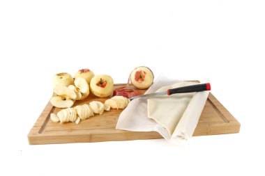 Tahta bir tahtanın üzerinde turta kabuğuyla kesilmiş ve soyulmuş elmalar. Elmalı turta için hazırlık.