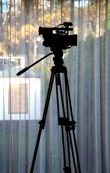 Σιλουέτα Της Βιντεοκάμερας Ένα Τρίποδο Πάνω Από Παράθυρο — Φωτογραφία Αρχείου