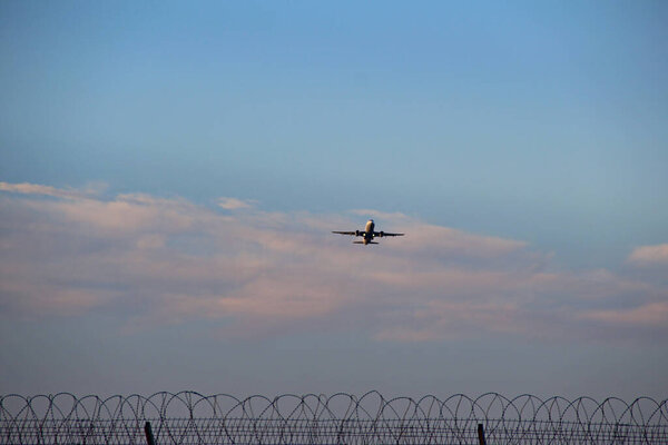 Takeoff Of A Passenger Airliner Over The Fence With Barbed Wire