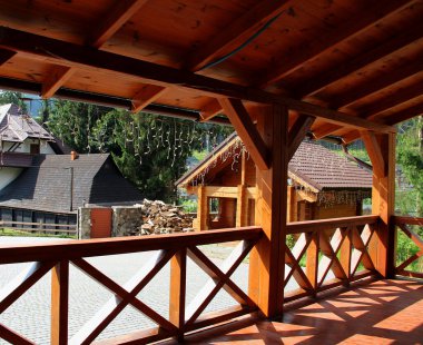Terrace railing and patio of country cottage with firewood stacked near woodshed 