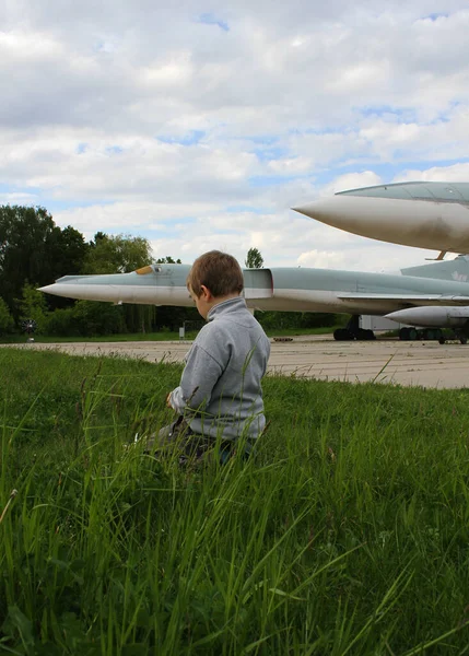 Niño Está Sentado Hierba Verde Cerca Pista Aterrizaje Aeródromo Militar — Foto de Stock