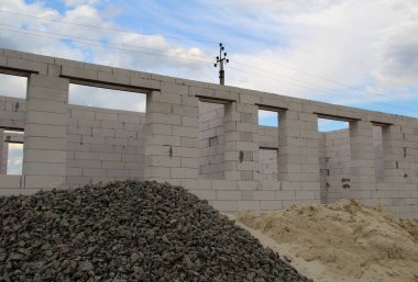 Bitmemiş bir köpük bloğunun önünde moloz ve kum yığını.