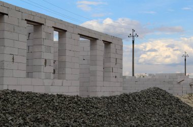 Köpüklü beton tuğlaların önündeki taş ve kum inşaat halindeki kulübenin önünde.