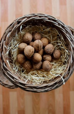 Tahta sepetin içindeki ahşap bir sepetin içindeki tüm cevizler dikey hikaye için.