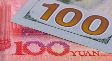 Üst üste binen 100 Çin yuanı ve 100 Amerikan doları.