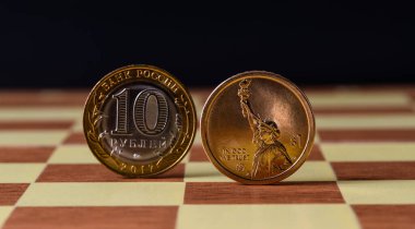 10 Rus rublesi ve satranç tahtasındaki 1 Amerikan Doları 'ndan oluşan paralar.