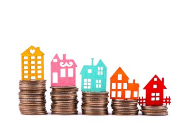 Beyaz arka planda ahşap sembolik evler ve paralar