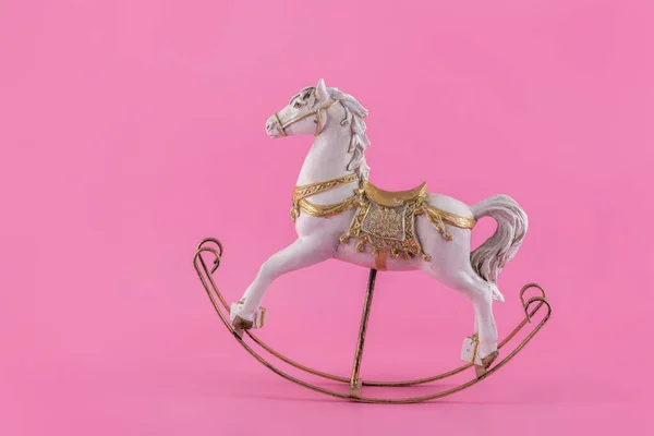 Antique stylized toy horse on a pink background