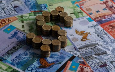 100 Kazakistanlı madeni para, bir dolar işareti ve Kazak banknotları şeklinde katlanmış.