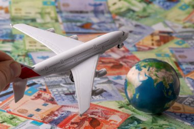 Kazakistan banknotlarının arka planında bir yolcu uçağı modeli - tenge