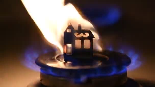 ガスバーナーの上に木造の家が立っているガスの問題を象徴するビデオが点灯し 完全に燃焼 — ストック動画