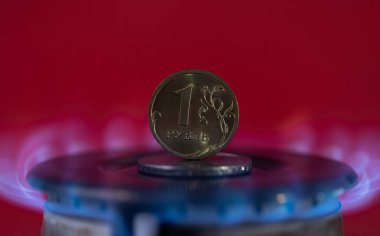 Bozuk para 1 Rus rublesi sıcak bir gaz ocağında duruyor.