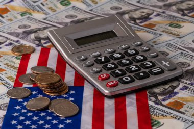 Amerikan bayrağının arka planında 1 ABD doları ve 25 sentlik madeni paralar