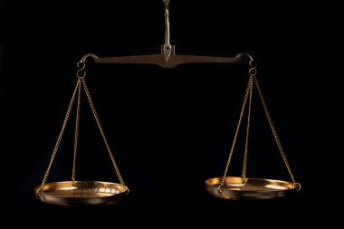 Gilded scales with two hanging bowls on a black background
