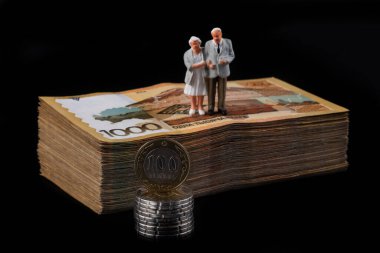 1000 Kazakistan parası, Kazakistan parası ve siyah arka planda yaşlı bir çiftin heykeli gibi banknotlar halinde.