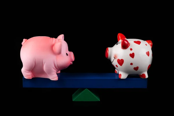 Two Piggy Banks Balancing Board Black Background — Stock Photo, Image