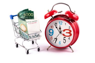 Kırgız banknotları. Minyatür bir alışveriş arabasında 5000 som ve kırmızı bir çalar saat.