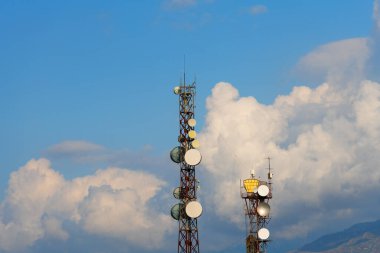 Communication masts against a cloudy sky