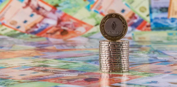 Coin with inscription 0 tenge on the background of Kazakhstani tenge