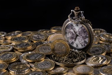 Antique pocket watch on a pile of Kazakh coins of 100 and 200 tenge