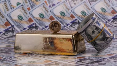 Büyük bir altın külçesi ve 100 Amerikan doları.