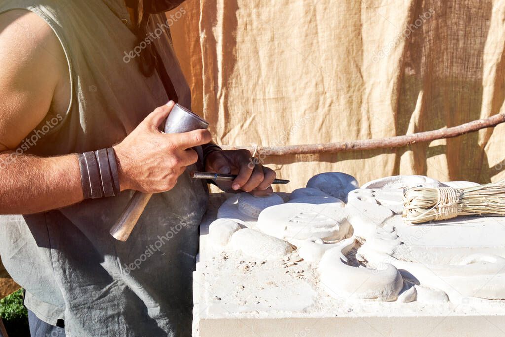 Craftsman carving stone in a traditional way. Concept of traditional and manual work