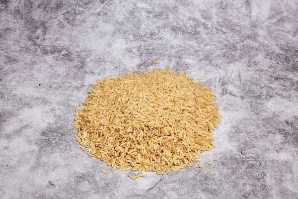 Gri Bir Arka Planda Pişmemiş Pirinç Yığını Asya Yemekleri Sağlıklı — Stok fotoğraf