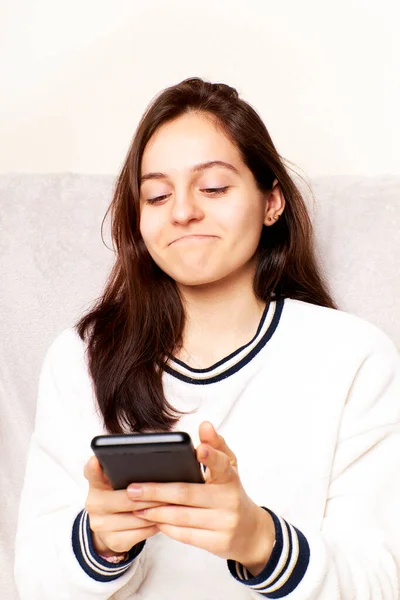 Girl gesturing when receiving a good news notification via cell phone, success on the Internet.