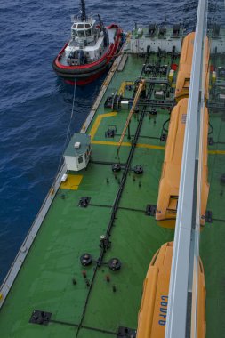 Geminin arka planında yakıt ikmali yapan bir petrol tankeri teknesi, denizin ortasında petrol tankeri teknesiyle yakıt ikmali yapan büyük bir yolcu gemisi.