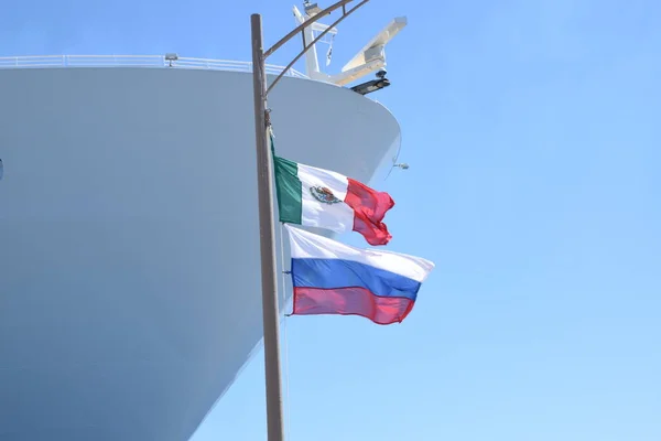 Mexican Flag waving with Russian flag on cruise port in Costa Maya, Mexico | Mexico and Russia flag together on pole in Mexico