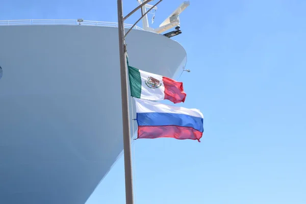 Mexican Flag waving with Russian flag on cruise port in Costa Maya, Mexico | Mexico and Russia flag together on pole in Mexico