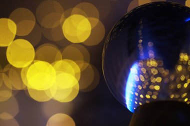Yerde Bokeh 'le kristal küre var. Renkli ışık saçan cam top, yeni yıl kutlaması konsepti..