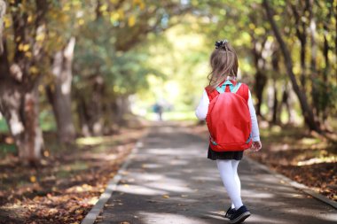 Parkta yürüyüş yapmak için çantalı çocuklar. Okul tatili. Çocuk eğitiminin başlangıcı..