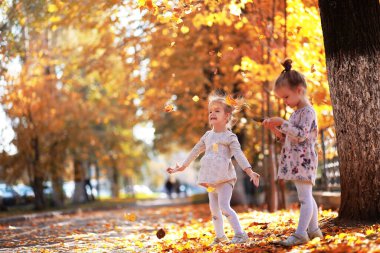 Yaprak parkta düşer. Sonbahar parkında yürüyüşe çıkmış çocuklar. - Aile. Düş! Mutluluk.