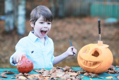 Sonbahar gelenekleri ve Cadılar Bayramı hazırlıkları. Doğada bir ev, masada balkabağından yapılmış bir lamba kesilir..