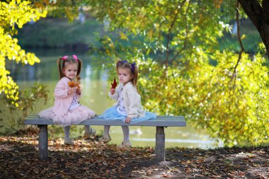 Yaprak parkta düşer. Sonbahar parkında yürüyüşe çıkmış çocuklar. - Aile. Düş! Mutluluk.