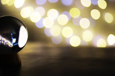 Yerde Bokeh 'le kristal küre var. Renkli ışık saçan cam top, yeni yıl kutlaması konsepti..