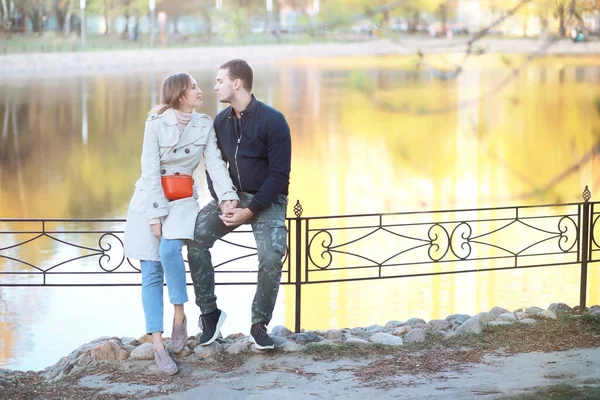 A man and a girl in love on a first date in autumn city park.