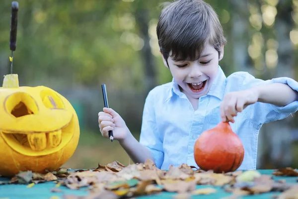 Autumn traditions and preparations for the holiday Halloween. A house in nature, a lamp made of pumpkins is cut out at the table.