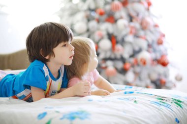 Mutlu noeller. Güzel bebek, Noel 'in tadını çıkar. Çocukluk anıları. Noel Baba kızı küçük çocuk Noel 'i evde kutluyor. Aile tatili. Tatlı kız, neşeli çocuk, Noel ağacının yanında oyun oynuyor..