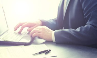 Müdür ofisteki bir dizüstü bilgisayarda çalışıyor. İşadamı çevrimiçi işlem yapıyor. Değiş tokuş internet üzerinden yapılıyor..