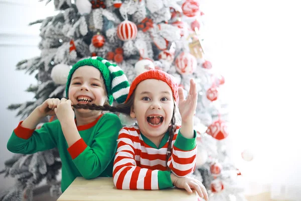 サンタクロースのヘルパークリスマスのために美しく装飾された部屋でクリスマスの自己の衣装でかわいい子供たち 奇跡の時だ サンタクロースからの贈り物 — ストック写真