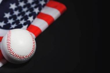Amerikan geleneksel spor oyunu. Beyzbol mu? Kavram. Amerikan bayrağıyla birlikte beyzbol topu ve sopalar masada..