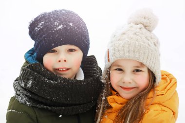 Mutlu bir aile kışın dışarıda karda oynar ve güler. Şehir parkı kış günü.