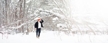 Kışın ormanda bir adam. Sırt çantalı bir turist kışın ormana gider..