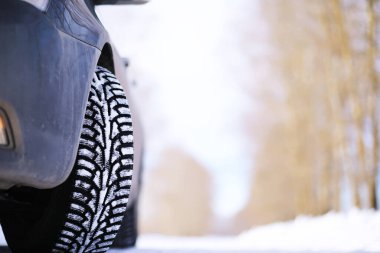 Modern SUV arabası kış yolunun kenarında duruyor. Kayak merkezine aile gezisi. Kış ya da bahar tatili macerası. Araba kışın karlı yolda dağlarda