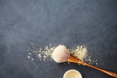 Toz ve makyaj fırçası. Arka planda kahverengi toz. Makyaj ürünleri. Biçim konsepti.